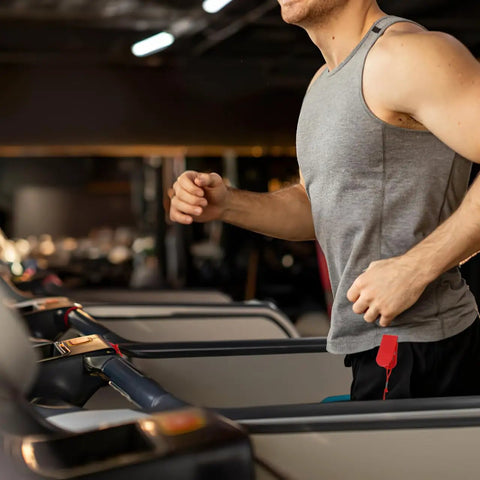 Man running on treadmill with red Treadmill Safety Key With Magnet Lock Replacement Kit attached to shorts in gym setting.