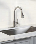 Heavy Duty Kitchen Faucet With Smooth Pull Down Sprayer In Top Shelf Brushed Nickel Rust Resistant Steel Body mounted in a modern kitchen sink.