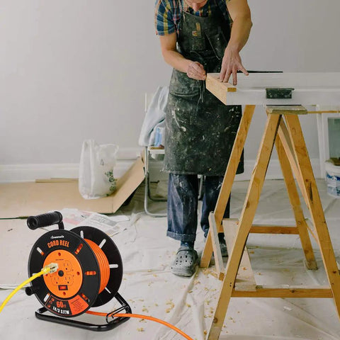 Heavy Duty Retractable Sixty Foot Extension Cord Reel With Metal Stand next to a person working on a wooden sawhorse