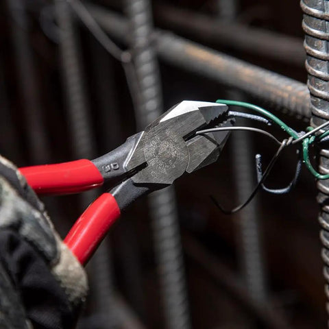 D201-7CSTA Linesman Pliers With Spring Loaded Action cutting soft annealed rebar tie wire, displaying kickass grip and aggressive knurl.