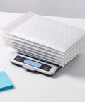 Stack of 30 Pack 6 By 8 Inch Bubble Mailers Self Seal Envelopes Waterproof Protective Mailing Bags on digital scale