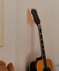 Ultimate Guitar Neck Rest Repair Kit With Premium Basswood Work Mat For Electric And Bass Care Luthier Essentials Easy Portable Travel Setup on wall with guitar.