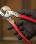 Beefy 9-Inch High Leverage Cable Cutter For Aluminum Copper And 100-Pair Communications Cable Made In USA Precision One-Hand Shear Cable-Gripping Jaws Built For Tight Spaces held in a gloved hand
