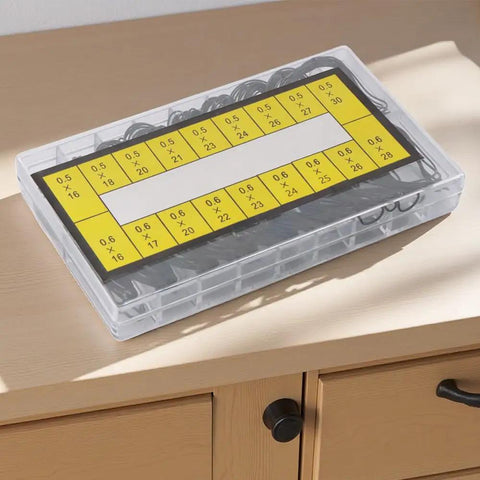 Plastic box with 180 Piece Watch O Ring Gasket Set With 18 Types For Different Sizes, 0.5mm And 0.6mm Diameters on wooden table