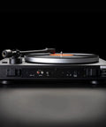 Dual CS429 Fully Automatic Belt Drive Turntable In Sleek Black With Ortofon 2M Red Cartridge seen from the side with a vinyl record.