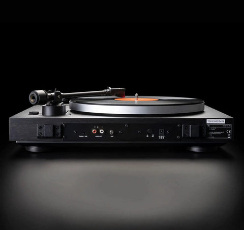 Dual CS429 Fully Automatic Belt Drive Turntable In Sleek Black With Ortofon 2M Red Cartridge seen from the side with a vinyl record.