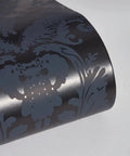 Close-up of textured black damsel damask peel and stick wallpaper with metallic gray details, 20.5 in x 16.5 ft roll, made in the USA.