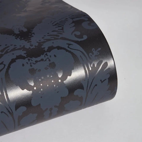 Close-up of textured black damsel damask peel and stick wallpaper with metallic gray details, 20.5 in x 16.5 ft roll, made in the USA.