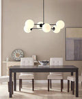 Dining room with Six Light Sputnik Chandelier In Matte Black With Globe Glass Shades over modern table and chairs
