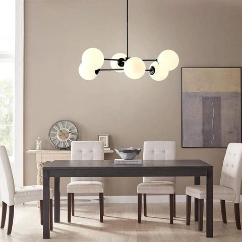 Dining room with Six Light Sputnik Chandelier In Matte Black With Globe Glass Shades over modern table and chairs