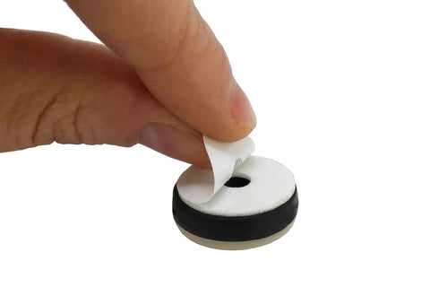 Heavy Duty 7/8 Inch Round Furniture Sliders Featuring Zero Friction Glide Tech For Slick Carpet And Wood Floor Moves While Shielding Surfaces From Scuffs Tan 8 Pack being peeled off a protective layer for easy application.