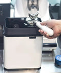 Badass Electric Portafilter Cleaner Knock Box With 150W Motor And Stainless Steel Body For No Sweat Coffee Ground Disposal Including Quick Scraper Tool in use with portafilter.