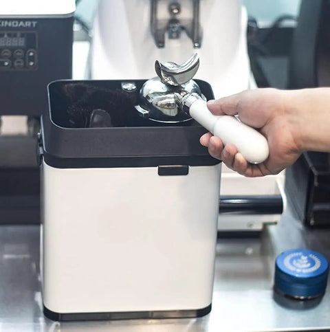 Badass Electric Portafilter Cleaner Knock Box With 150W Motor And Stainless Steel Body For No Sweat Coffee Ground Disposal Including Quick Scraper Tool in use with portafilter.