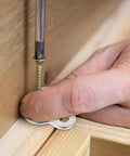 Close-up of Heavy Duty Figure Eight Table Connectors installation with iron clip and screw on wood, ensuring tight furniture assembly.
