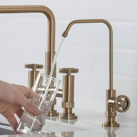Urbix Standalone On-Demand Lead-Free Kitchen Water Filter Faucet in Brushed Gold pouring water into glass