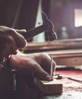 Person using hammer to drive nail into wood, depicting use of 400 Piece Hardware Nails Kit For Picture Hanging Galvanized Nails