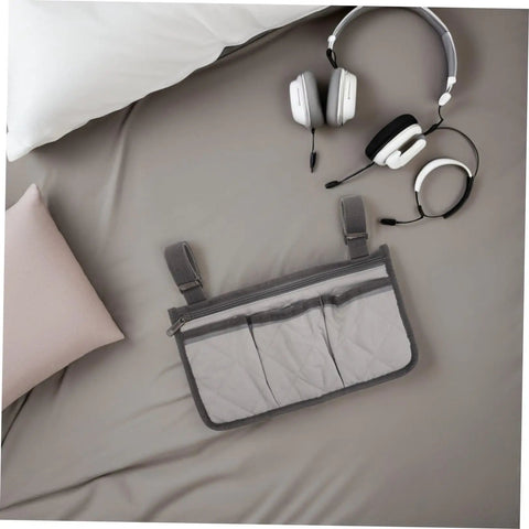 Gray Bed Rail Organizer Bag With Adjustable Strap And Four Storage Pockets beside headphones on bed