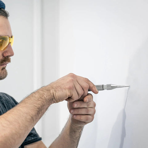 Man using 5 Inch Automatic Center Punch Set with Spring Loaded Action for Metal Wood Plastic Palm Cap Replacement Tips and Springs Included