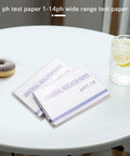 All Purpose PH Test Strips Kit Two Pack With Control Card 1 To 14 Range on a table with a drink and donut