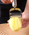 Front view of stainless steel 2-in-1 vegetable peeler and crinkle cutter slicing a peeled potato into fries