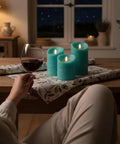 Turquoise Real Wax Flameless Candles Set Of 3 on table with wine glass, teal LED pillar candles with remote and timer