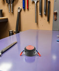 Top Shelf Emergency Essentials For Your Daily Driver Solid Compact Auto Fire Suppressor With Instant Aerosol Activation on a workshop table