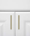 Golden Champagne Euro Bar Cabinet Pulls Five And Three Eighths Inch Length 3 Inch Hole Center One Half Inch Diameter Ten Pack on white cabinet doors.