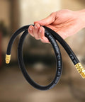 Tough As Nails Air Compressor Whip Hose 3/8 Inch By 3 Feet held in hand, showcasing flexible black hybrid rubber PVC design with brass fittings.