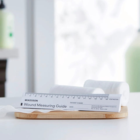 Wound Measuring Guide Ruler, 6 Inch Paper, Non Sterile, 50 Count, Calibrated for Super Handy Wound Progress Tracking in Both Metric And Imperial Units For Medical Staff And Home Use displayed on stand