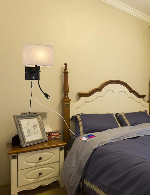 Plug In Black Wall Sconce With USB Port For Charging, Bedside Reading Lamp In Farmhouse Style next to a bed in a cozy bedroom