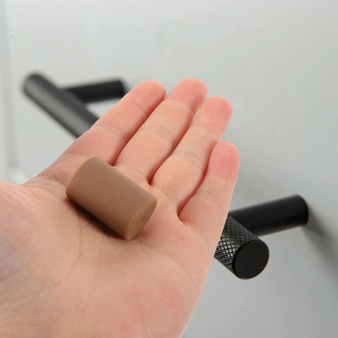 Brown Silicone Corner Guards For Furniture And Drawer Handles Soft Round Edge Protectors in a person's hand.
