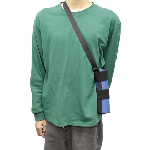 Person wearing green shirt with blue cylindrical item in black strap sling