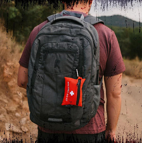 Red Lightning X mini first aid kit clipped to a gray backpack side pocket.