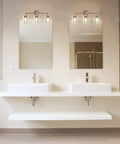 Three Light Matte Black Bathroom Vanity Lights With Clear Glass Shades above double sinks in modern bathroom