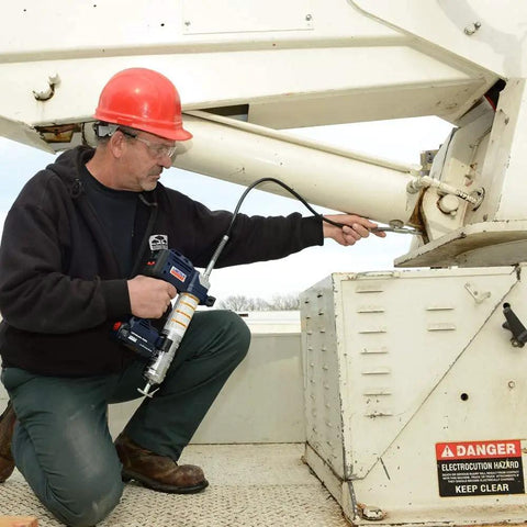 Technician using Lincoln 1884 PowerLuber 20V Battery Powered Grease Gun With 36 Inch Hose For Automotive, Agricultural And Industrial Equipment, 10,000 PSI, Trigger Operated, Two Speed, Includes Two Lithium Ion Battery Packs on machinery