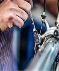 Person using Six Piece Metric Ratchet Wrench Set With Double Box End Flex Heads, 72-Tooth Gear, on a bike for repair