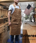 Man wearing waxed canvas woodworking apron with 9 tool pockets in workshop, ideal for DIY projects and builders.