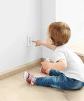 Child sitting near wall with Wall Switch Guard 2 Pack Kid Proof Light Switch Cover With Toggle Style Protection to prevent tampering.