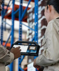 Two field technicians using a Built Like A Tank 10.1 Inch Rugged Tablet With Intel Core I7 in a warehouse setting.