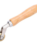Seam roller with wooden handle and brass wheel for wallpaper and roofing membranes