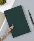 Extra Fine 0.28mm Gel Pens Black Ink Go To School Office Set With Transparent Tube Case Six Pack Smooth Writing Ball Point Pens For Notes And Drawings Everyday next to a green notebook on a desk with decorative items.