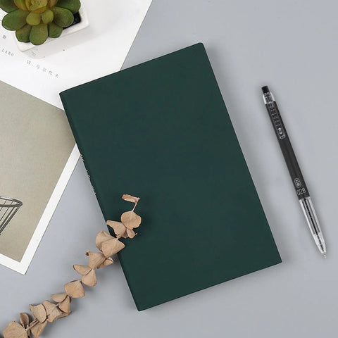 Extra Fine 0.28mm Gel Pens Black Ink Go To School Office Set With Transparent Tube Case Six Pack Smooth Writing Ball Point Pens For Notes And Drawings Everyday next to a green notebook on a desk with decorative items.