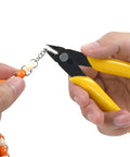 Close-up of yellow-handled micro flush cutter cutting beaded jewelry chain.