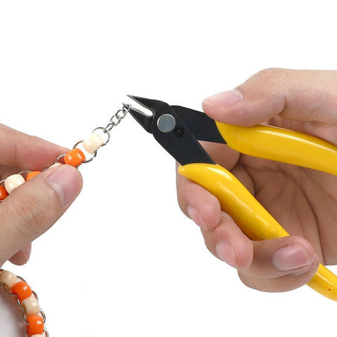 Close-up of yellow-handled micro flush cutter cutting beaded jewelry chain.