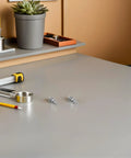 Solid Stainless Steel 108 Piece Machine Screw Nuts And Washers Assortment Kit Bolts on a workspace with tools.
