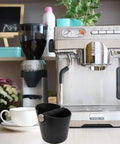 Espresso Knock Box 4.8 Inch Barista Style Grounds Bin With Removable Heavy-Duty Metal Knock Bar next to espresso machine.