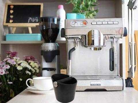 Espresso Knock Box 4.8 Inch Barista Style Grounds Bin With Removable Heavy-Duty Metal Knock Bar next to espresso machine.