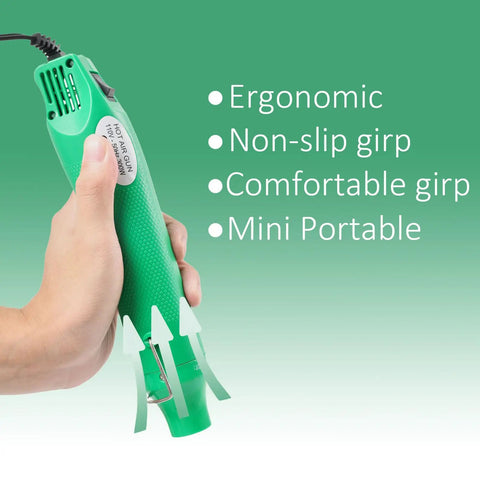 Hand holding a portable green heat gun 110V 300W with ergonomic, non-slip grip, ideal for shrinking PVC wrap and embossing.