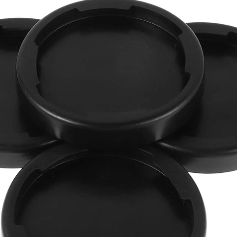 Close-up of four black round shock absorbing floor pads for home gym, non-slip base mats for treadmills and weightlifting.