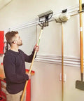 Man organizing tools with VersaTrack Garage Storage Rail With Twenty Piece Mounting Accessories For Drywall Studs And Masonry Pegboard